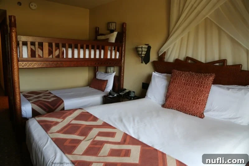 Cozy hotel room with a queen bed and a vibrant set of bunk beds, ideal for families staying at Animal Kingdom Lodge