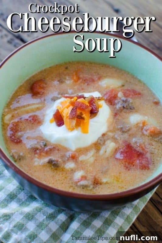 Creamy Crockpot Cheeseburger Soup topped with sour cream, bacon, and chives in a rustic bowl.