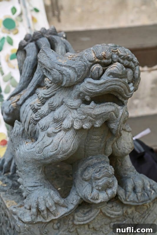 A small, ornate concrete animal statue, part of the decorative elements at Wat Arun temple complex