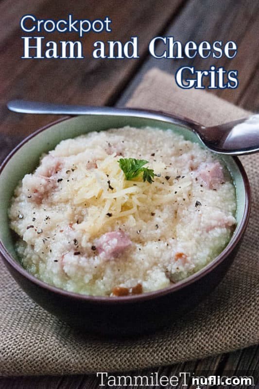 A close-up shot of creamy Crock Pot Ham and Cheese Grits in a bowl, with a spoon resting in it, ready to be enjoyed.