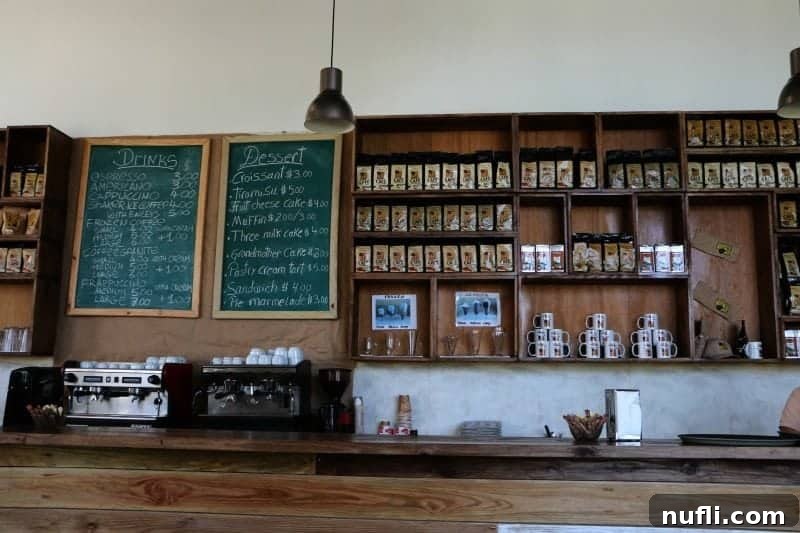 Behind a coffee counter with a menu and bags of coffee