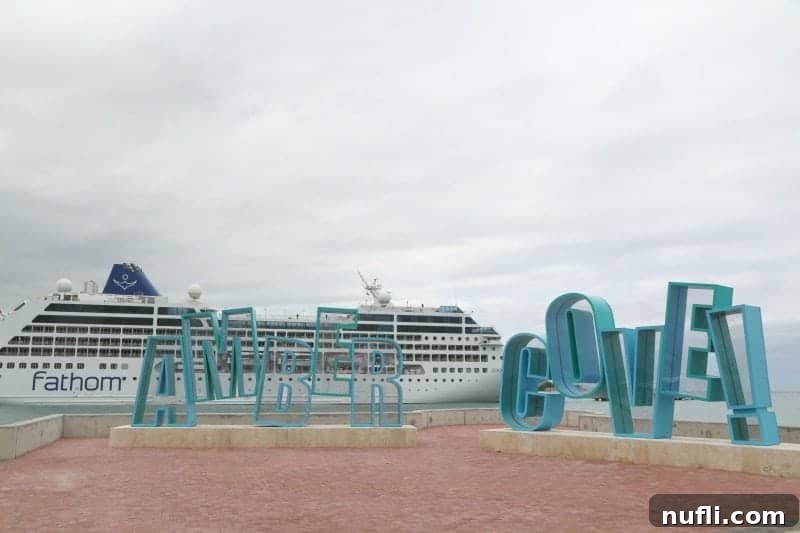 Amber Cove sign in front of a cruise ship at dusk