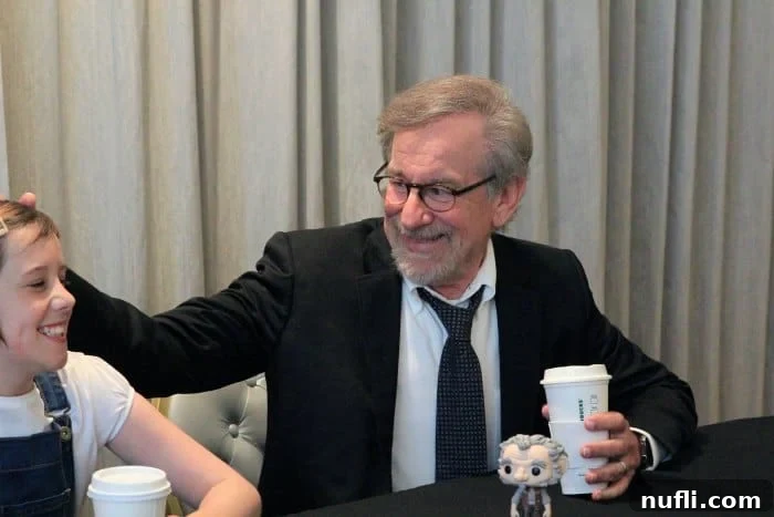 Steven Spielberg at a table with a starbucks cup 