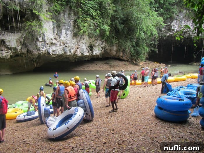 Belize's Epic Cave Tubing Adventure 9 people getting onto intertubes in a river near a cave