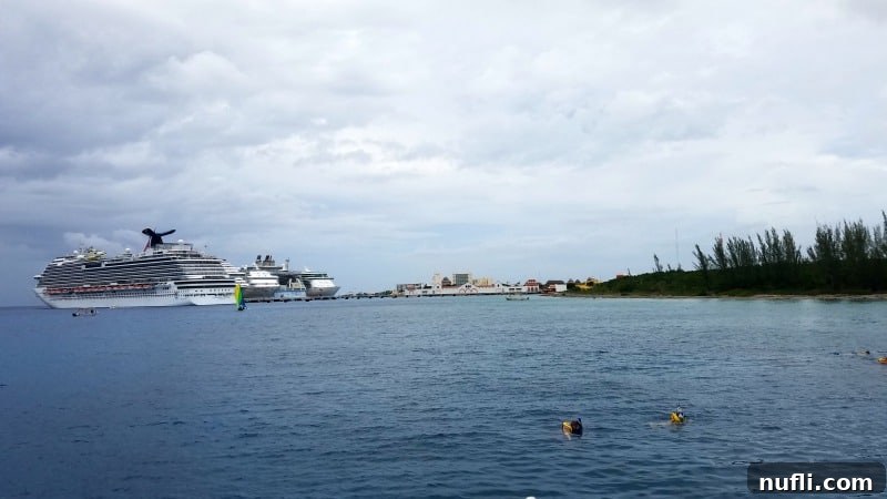 Snorkelers enjoying the clear waters of Cozumel with majestic Carnival cruise ships visible in the distance.