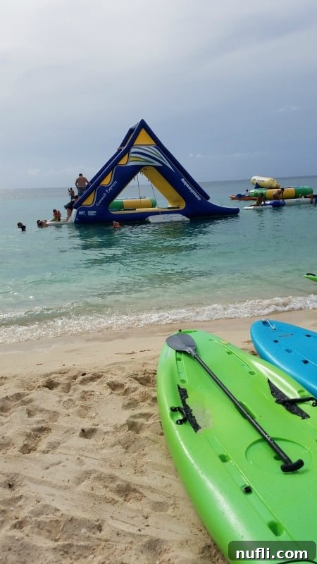 An array of fun water toys and paddleboards lining a picturesque beach in Cozumel, inviting guests to play.