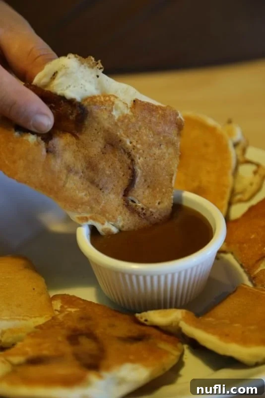 Golden brown pancake served with crispy bacon dippers, perfectly drizzled with maple syrup.