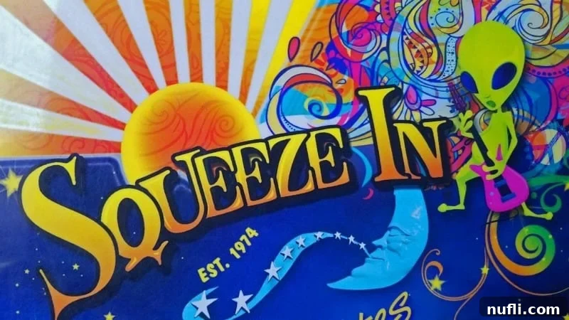 The 'Squeeze In' restaurant sign, featuring a playful green alien logo, inviting patrons inside.