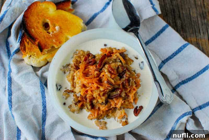 carrot cake oatmeal in a bowl with a spoon resting on it, next to toast