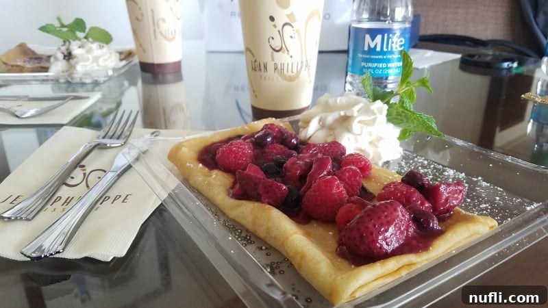 Delicious strawberry crepe from Jean Philippe Patisserie, served on a platter with accompanying coffee cups.