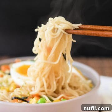 chopsticks holding noodles above an easy ramen bowl
