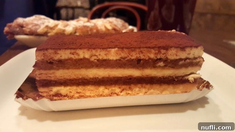 Exquisite layered Tiramisu on a pristine white plate, a tempting dessert from Main Street Bistro and Bakery