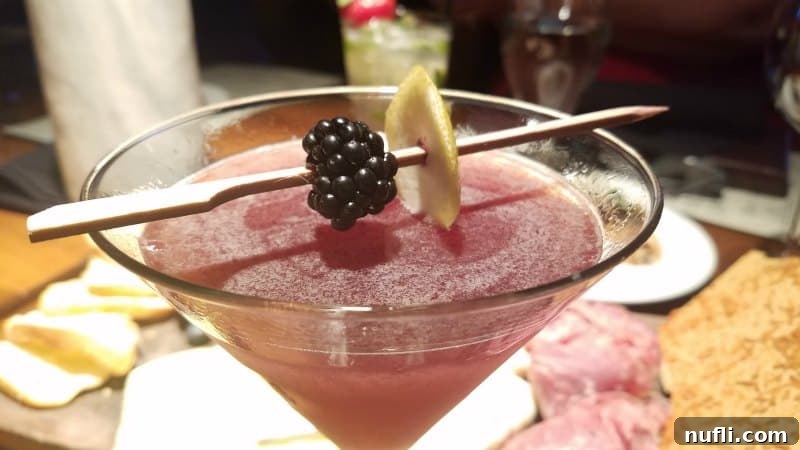 A refreshing martini garnished with a blackberry, suggesting delightful culinary experiences in Grapevine.