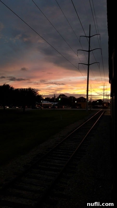 A picturesque sunset viewed from a train window, hinting at the scenic journeys of the Grapevine Vintage Railroad.