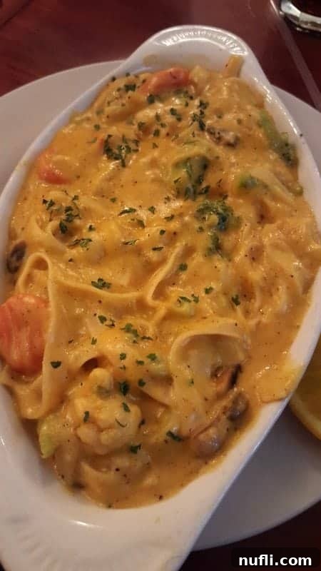 A delectable pasta dish with a creamy sauce and fresh ingredients, served on a white plate.