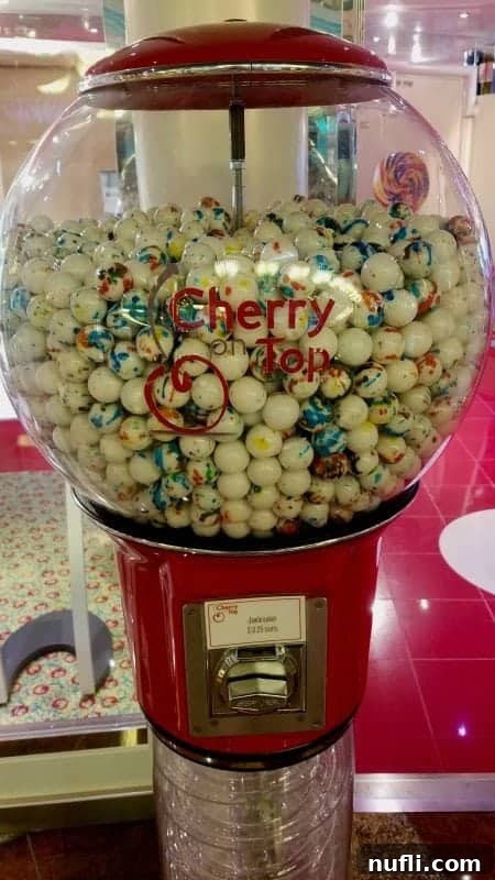 A Cherry on Top candy machine, brimming with colorful jawbreakers, tempting passersby with sweet treats.