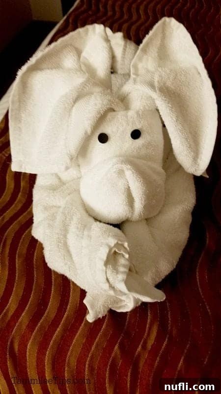 An adorable towel animal rabbit, skillfully crafted and awaiting guests in their stateroom.