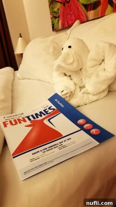 A charming towel animal positioned next to the Carnival Fun Times daily newsletter, a perfect greeting for cruise guests.