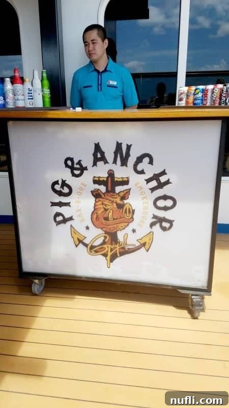 Guy Fieri's Pig and Anchor sign with a friendly waiter standing behind it, inviting guests to enjoy some delicious BBQ.