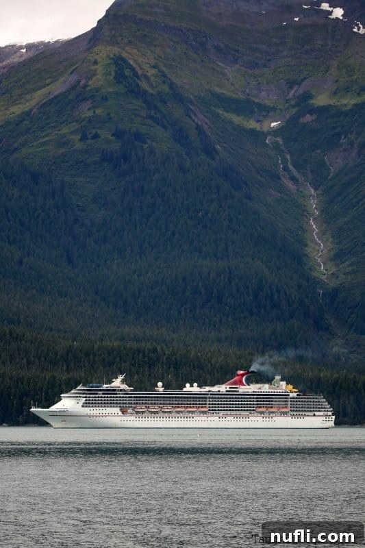 Carnival cruise ship on the water with huge mountain behind it