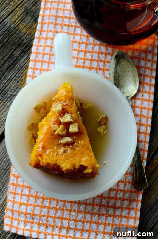 Pumpkin dump cake in a white bowl sitting on an orange and white towel next to a spoon 