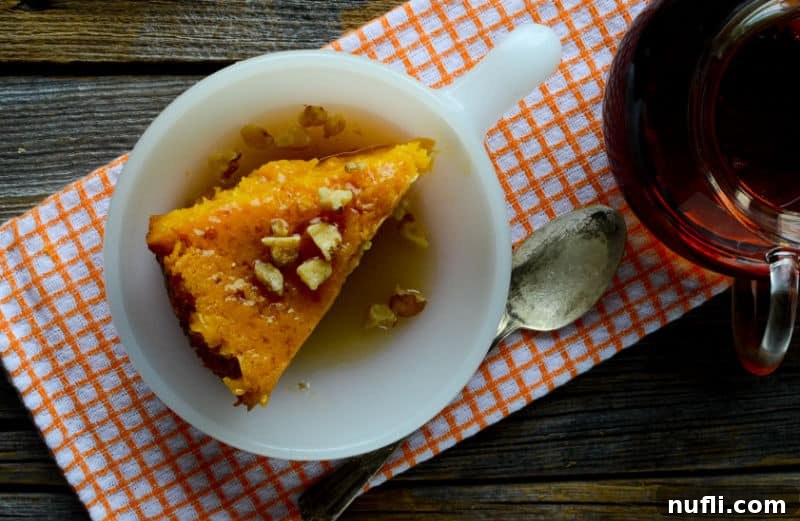 Pumpkin dump cake in a white bowl sitting on an orange towel with a spoon 
