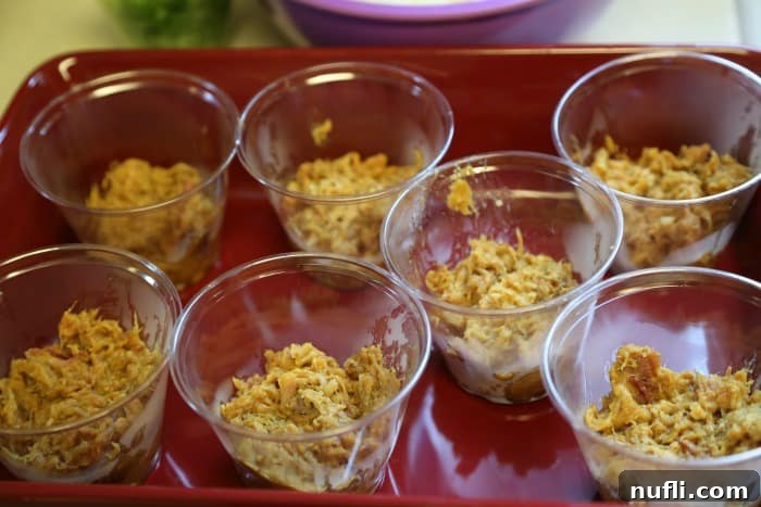 Layered Pulled Pork Perfection 4 Plastic cups with pulled pork in them in a red tray