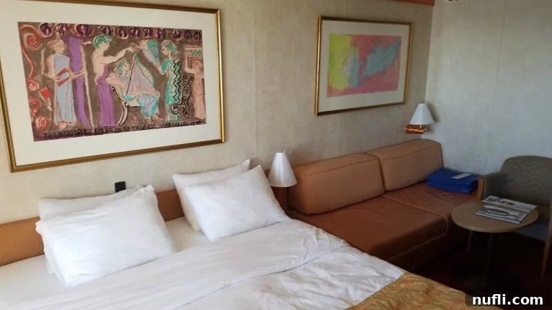 Carnival Legend stateroom with painting over the bed, couch next to the bed