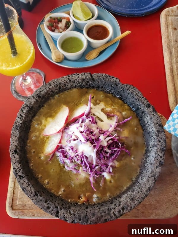 Molcajete with bubbling liquid and melted cheese, a traditional Mexican dish.