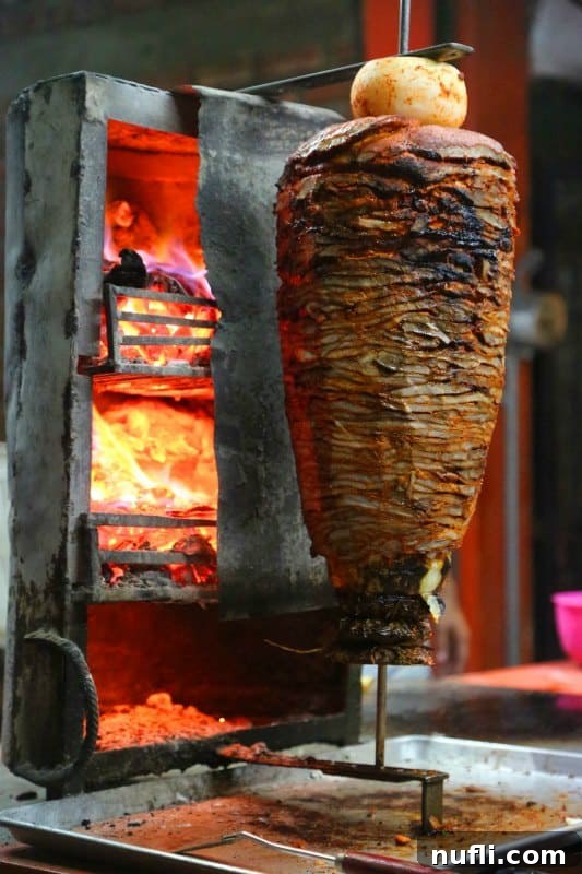 Meat cooking on a stick next to a hot fire box, representing authentic street food preparation.