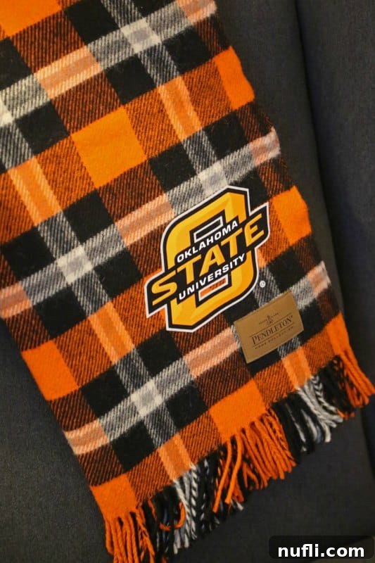 Oklahoma State University's Atherton Hotel in Stillwater 7 A high-quality Oklahoma State University blanket from Pendleton Woolen Mills draped over furniture, showcasing collegiate pride and comfort.