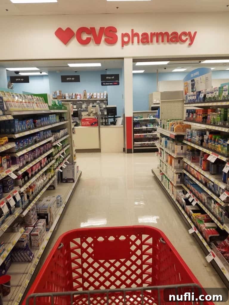 A red shopping cart moving down an aisle inside a CVS Pharmacy at Target.
