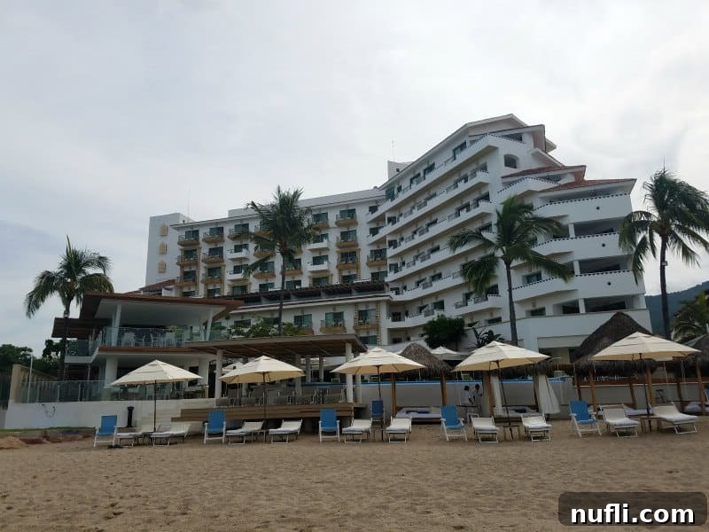 Exterior of VIlla Premiere with lounge chairs and umbrellas on the beach 