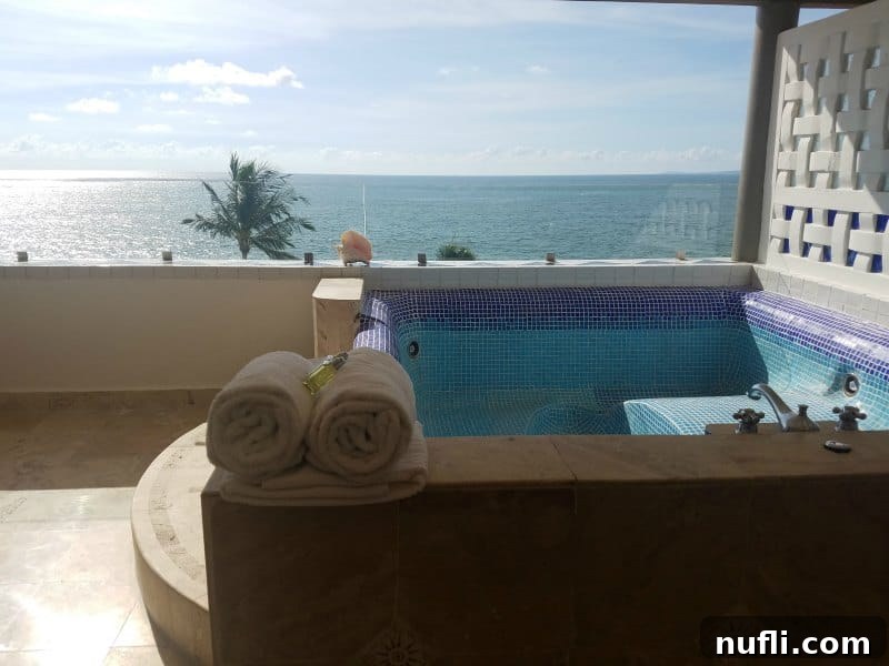 Hot tub on a balcony with towels next to it looking out at the Bay of Banderas 