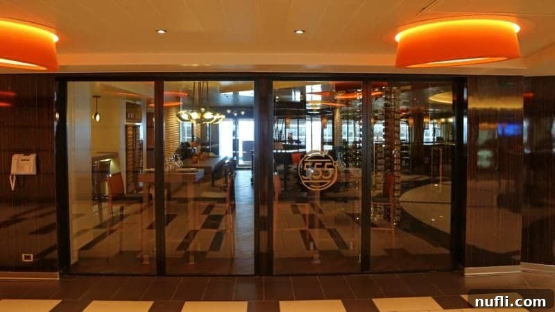 The sophisticated glass door entrance to Fahrenheit 555 Steakhouse, promising an upscale dining experience.