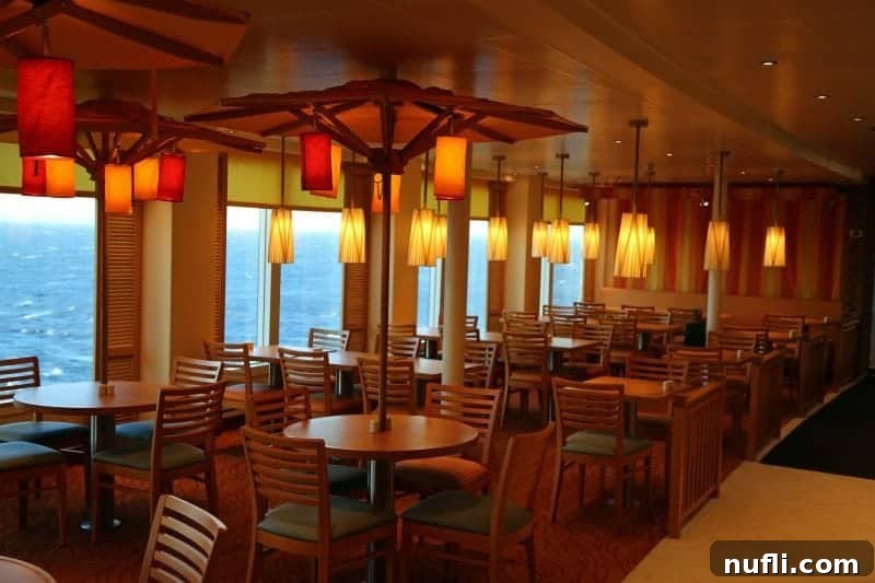 tables and chairs near the window slooking out on the ocean 