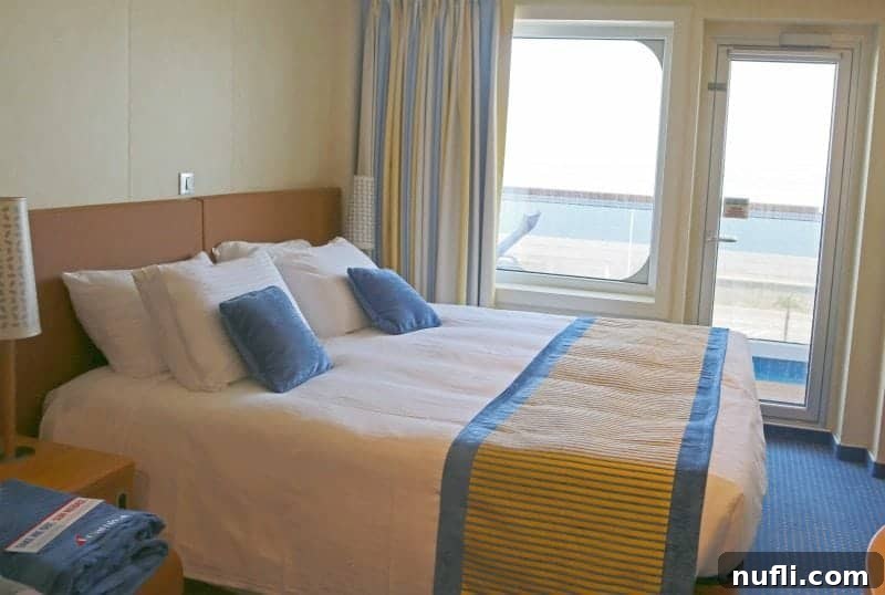 Carnival vista stateroom with a bed near glass doors and the balcony