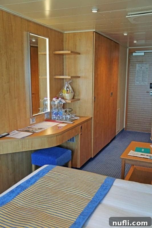 Carnival vista state room with a cabinet, wter bottles, and basket of fruit 