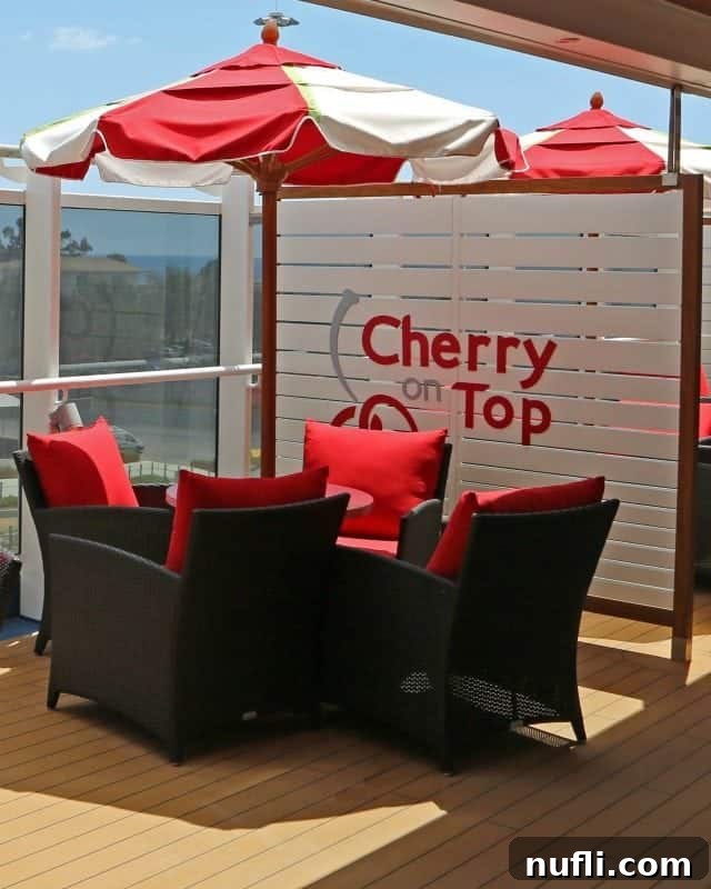 The playful Cherry on Top sign, located near cozy chairs and a cheerful red and white umbrella, promising sweet delights.