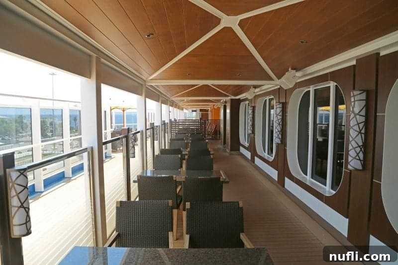 Ample outdoor seating along the deck of the Carnival Vista, providing various spots for guests to relax and enjoy the sea.