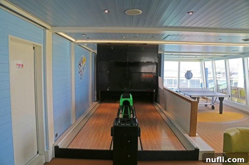 A vibrant mini bowling game setup, conveniently located near a ping pong table, offering dual entertainment options.