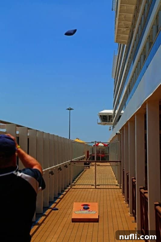 A lively cornhole game set up on the Carnival Vista's deck, ready for guests to enjoy outdoor fun.