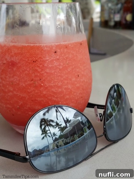 sunglasses reflecting the pool next to a margarita