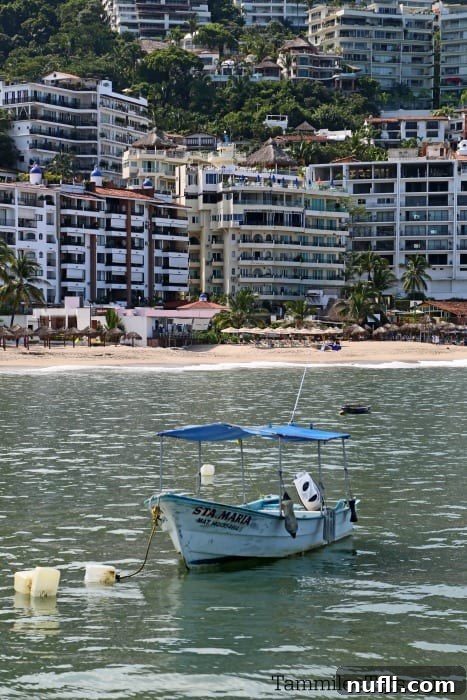 small boat floating in the water with buildings behind it