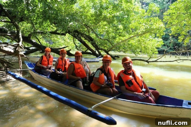 Five people in orange life jackets on a small outrigger canoe boat, symbolizing shared travel experiences.