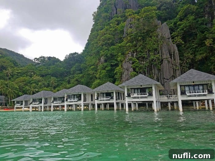over water bungalows with jungle behind them. 