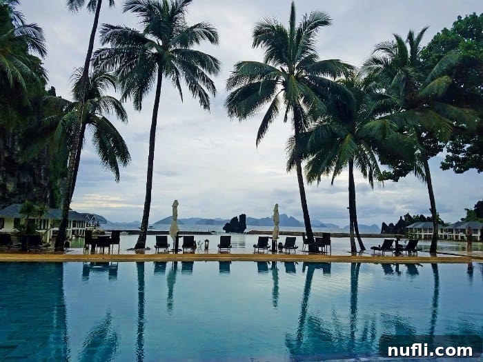pool with palm trees reflecting in the water looking out to the bay 