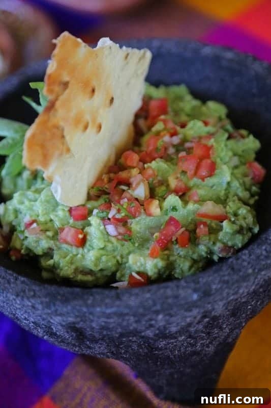 Authentic Mexican guacamole served in a traditional molcajete with tortilla chips on the side