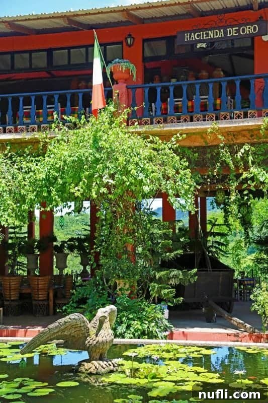 A serene pond covered with lily pads, with the 'Hacienda de Oro' restaurant's open-air deck visible in the background