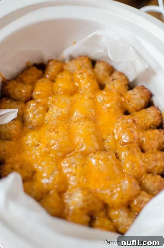 Tater tots covered in cheese in a crockpot